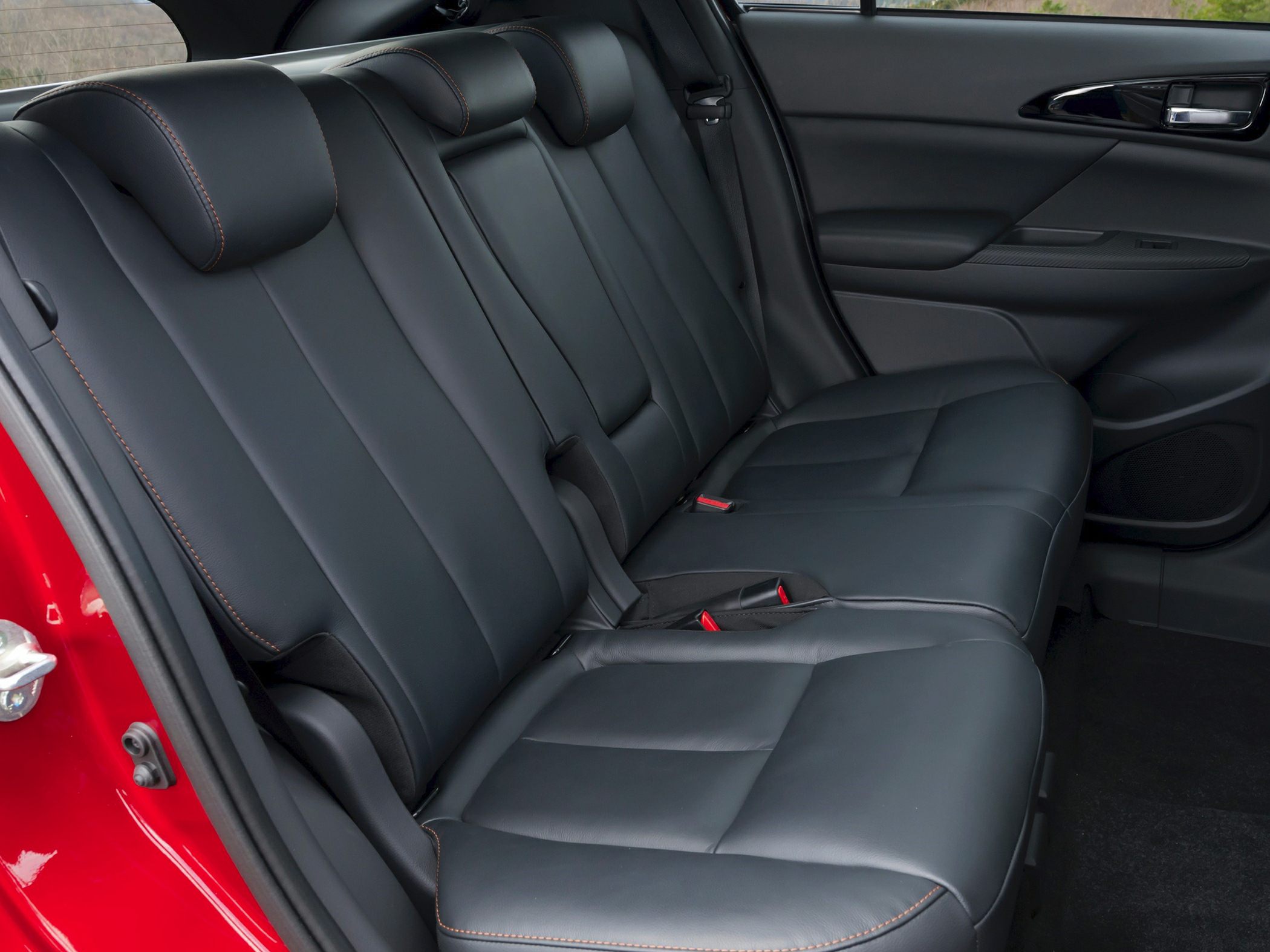 Black leather rear seats with orange stitching and headrests