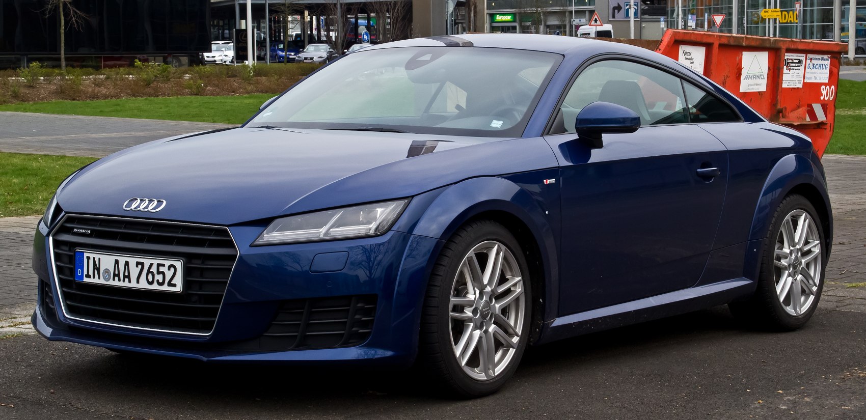 Side-front view of blue sports coupe with sharp headlights and bold grille
