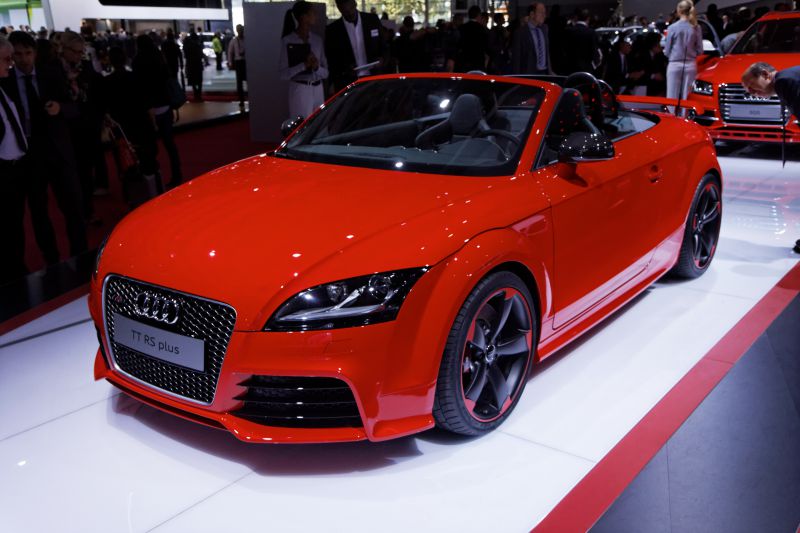 Red convertible with sporty front grille and alloy wheels.