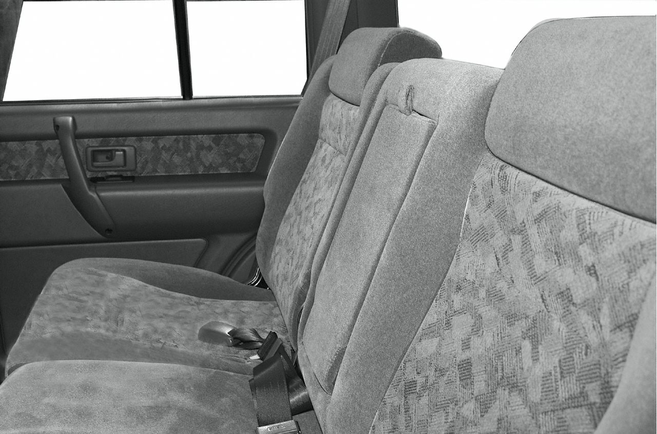 Rear seat with patterned fabric upholstery, integrated headrests, and seat belts