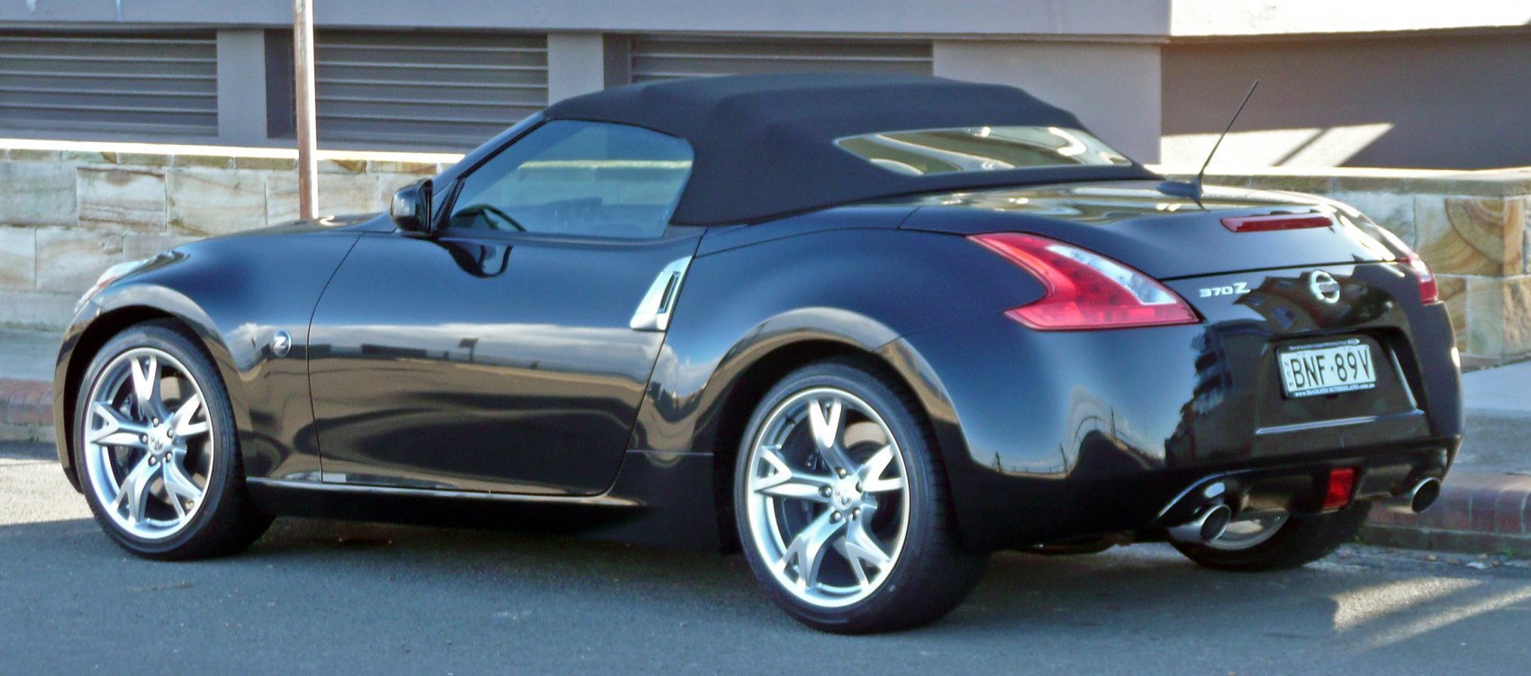 Convertible soft top, dual exhaust, sporty alloy wheels, rear side view