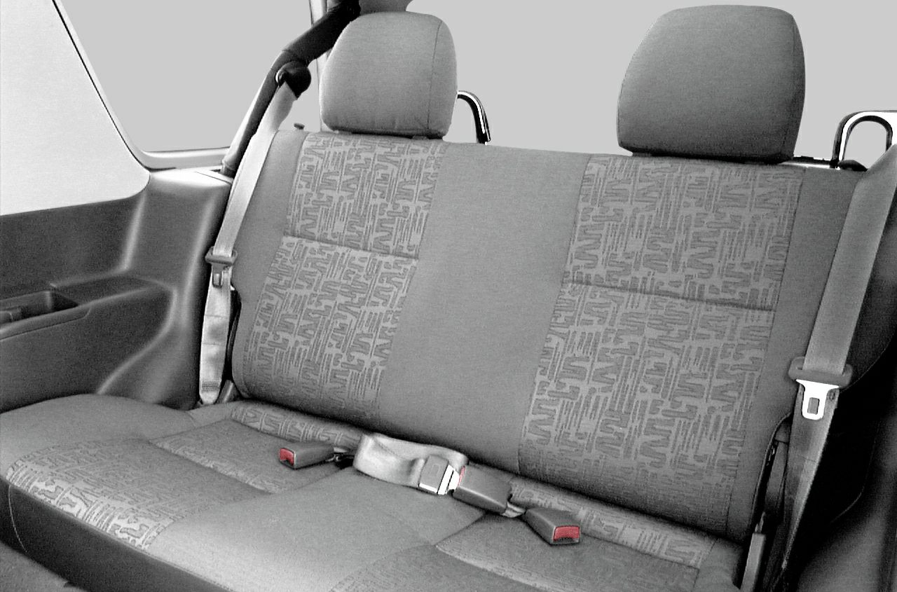 Rear seat upholstery with seat belts and headrests inside vehicle cabin