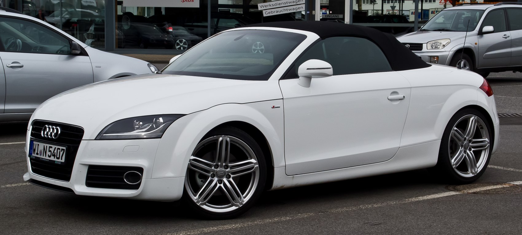 White convertible with black soft top and alloy wheels