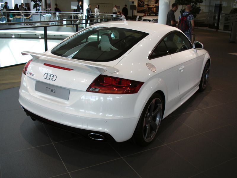 Rear view of a white TT RS coupe with rear wing spoiler and dual exhaust