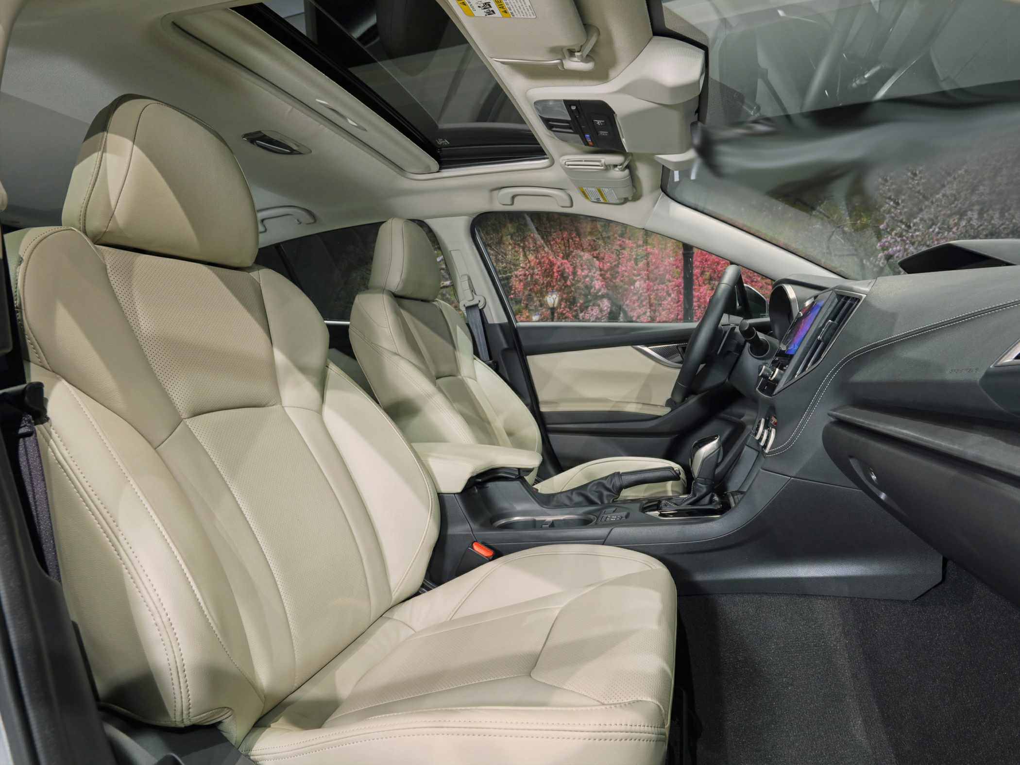 Beige leather seats and panoramic sunroof in front cabin view