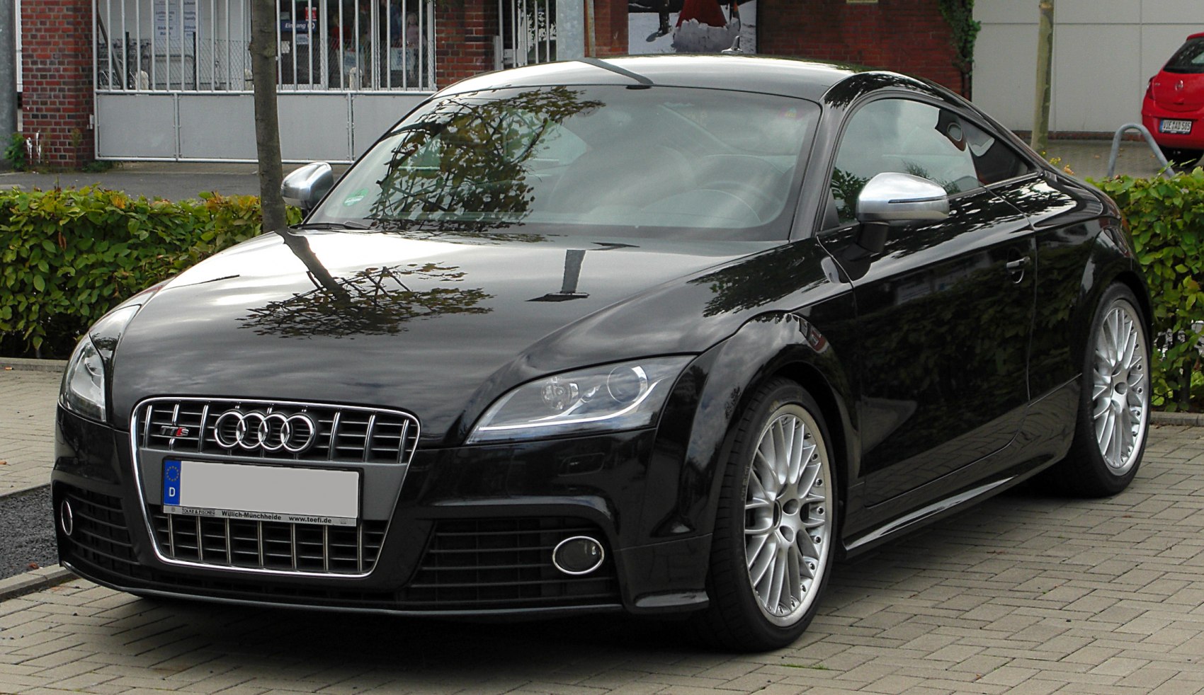 Black sporty coupe with distinctive grille, sleek headlights, and alloy wheels