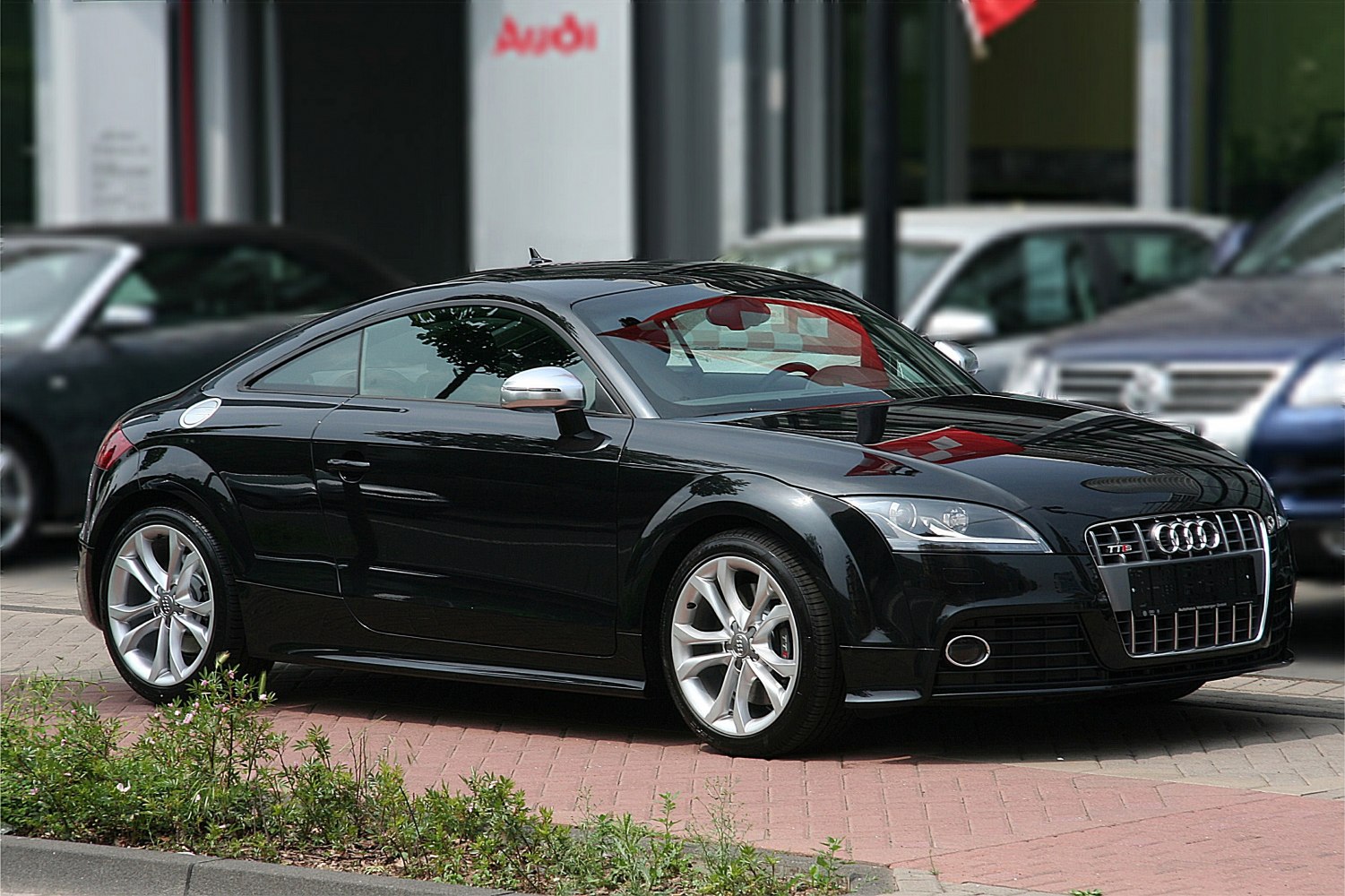 Sleek black coupe with distinctive front grille and silver alloy wheels