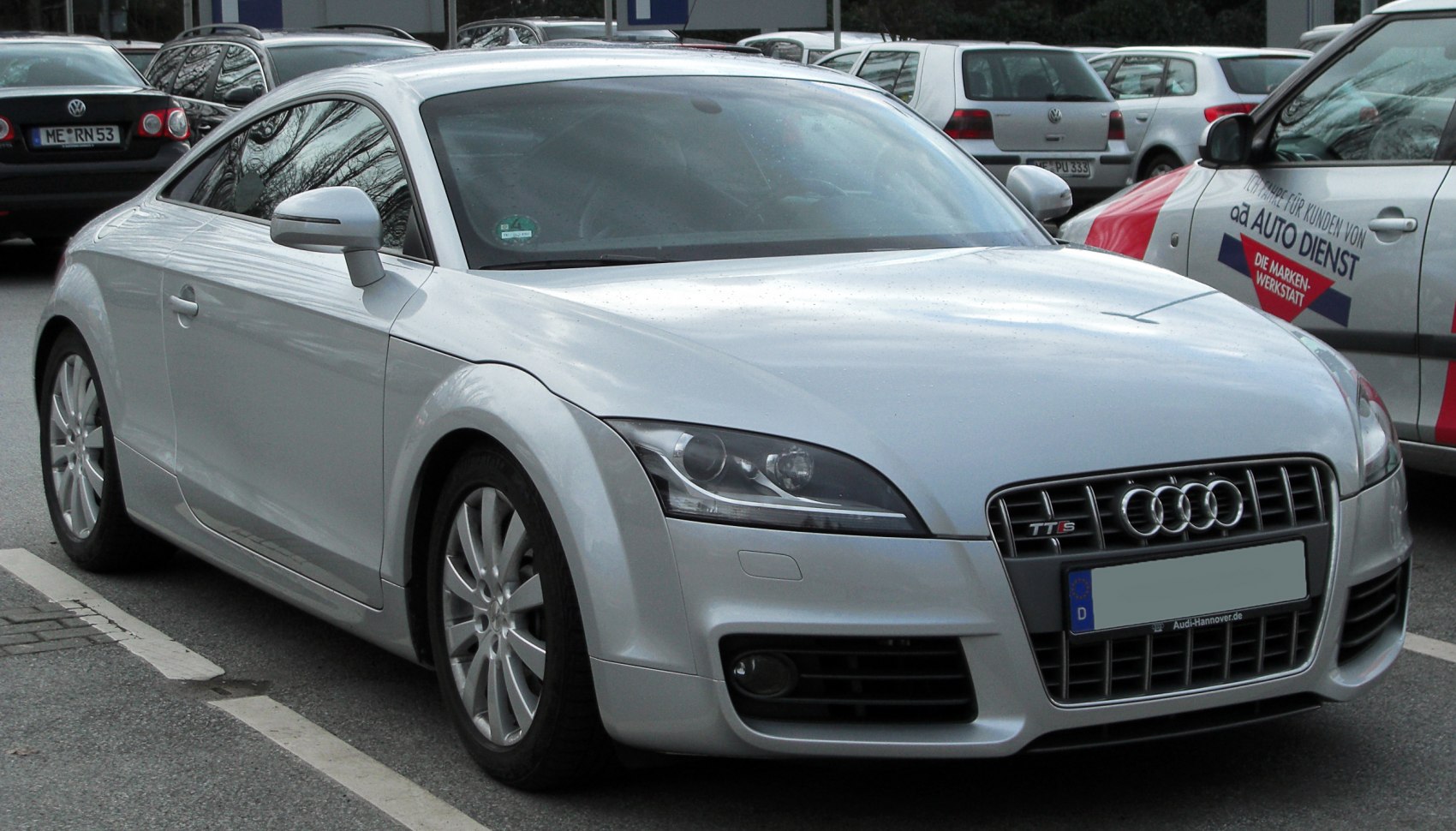 Sporty coupe front right view with sleek headlights and grille.