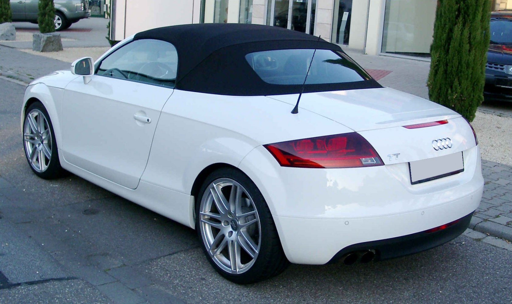 Rear-side view of convertible with soft top and alloy wheels