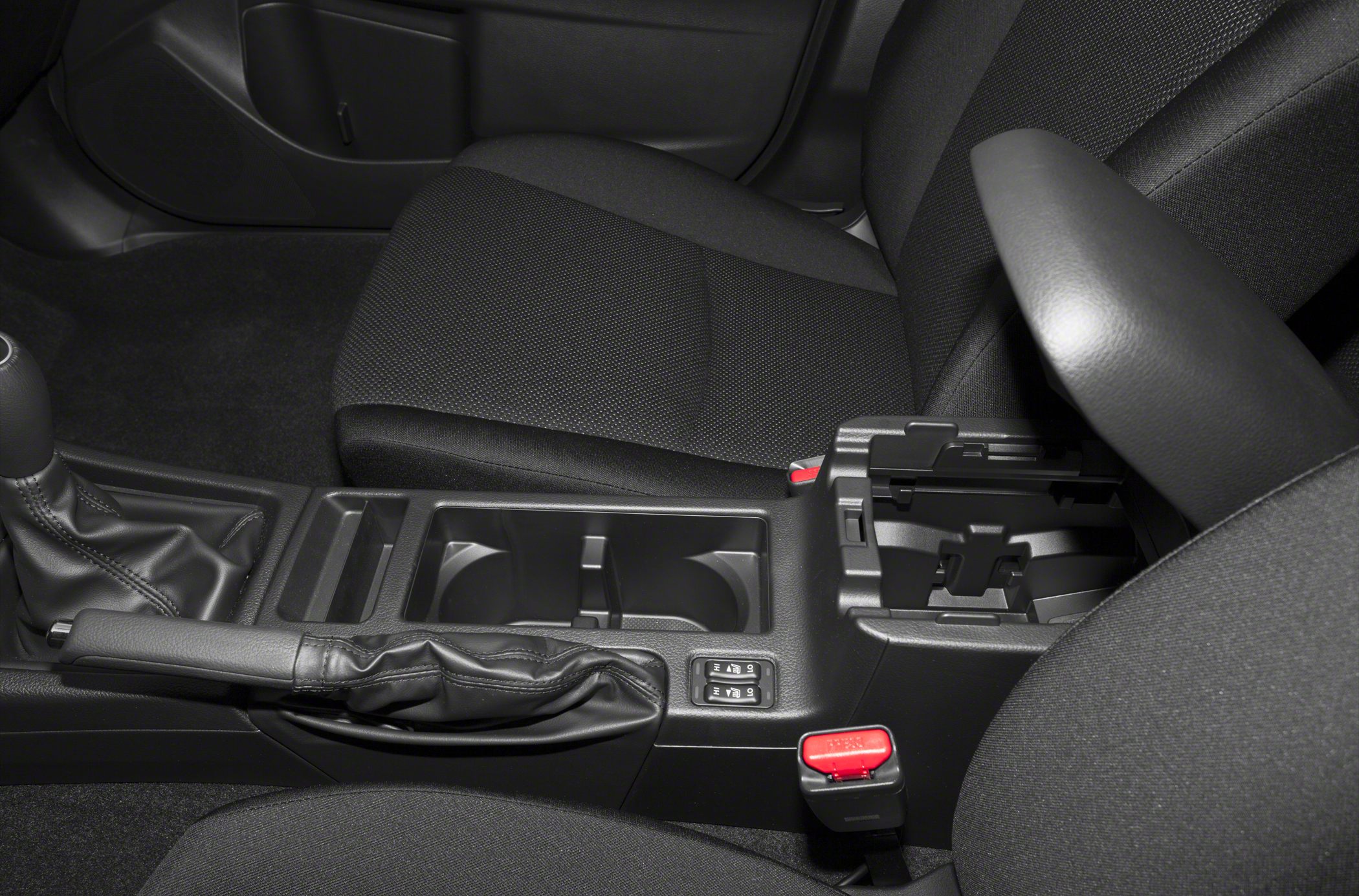Center console with handbrake, armrest, cup holders, and seat heater controls.
