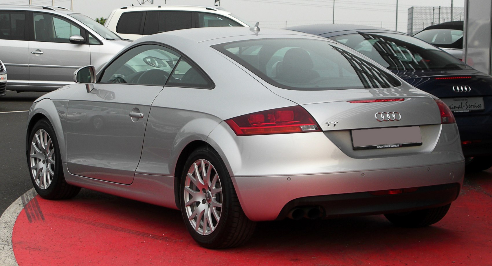Silver two-door coupe rear side with distinct tail lights and alloy wheels