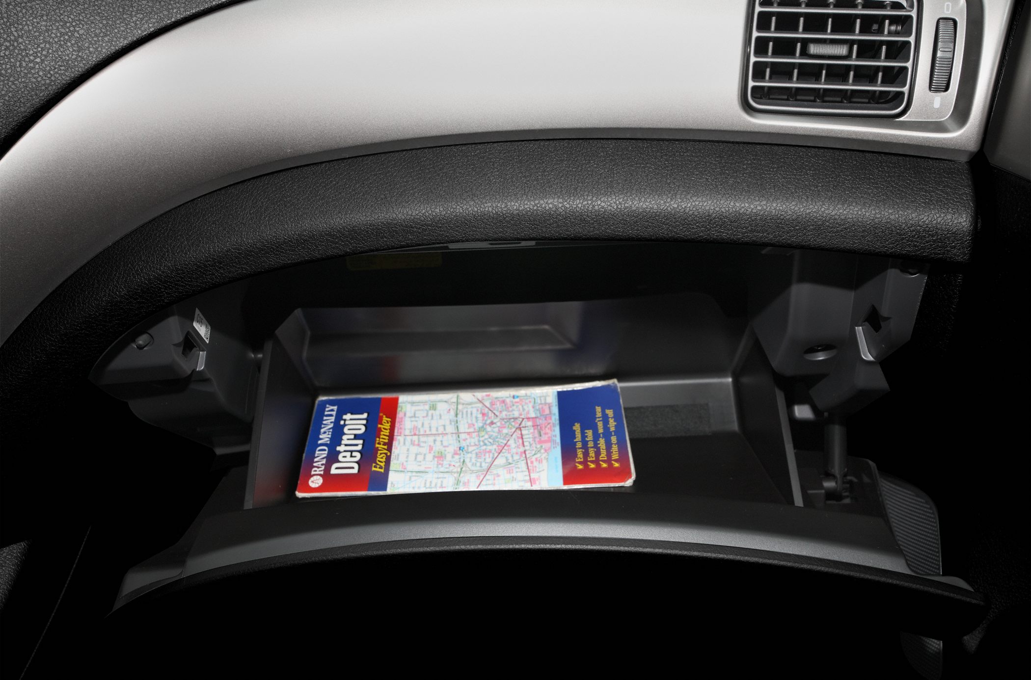 Open glove compartment with a city map inside