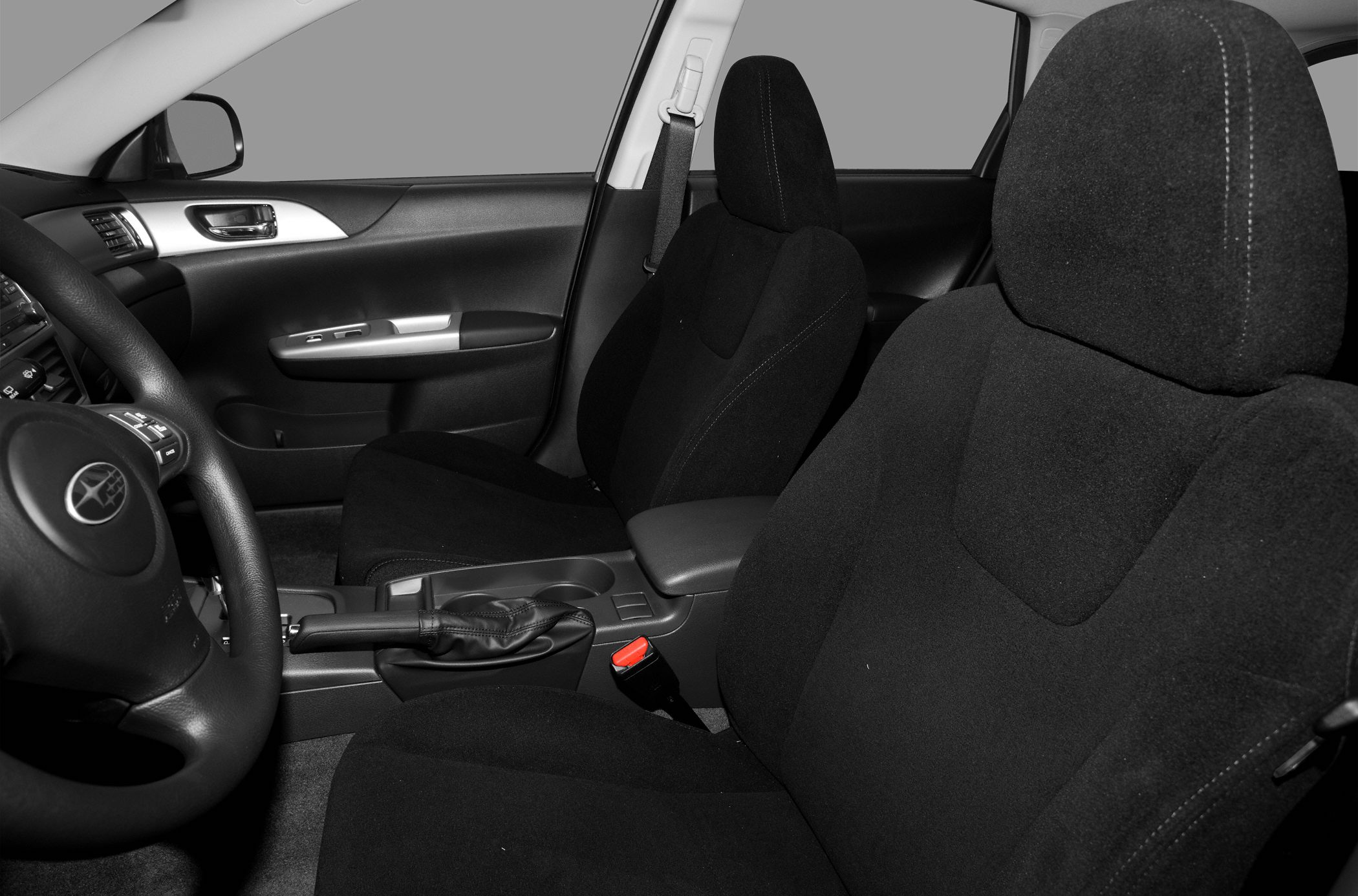 Black fabric front seats and dashboard interior with handbrake and cup holders.
