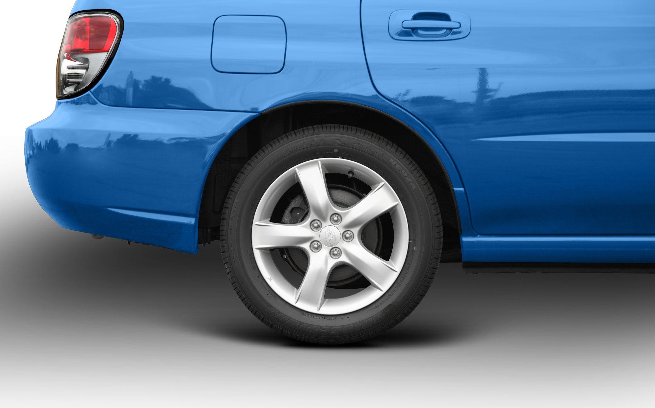 Rear wheel, alloy rim, tail light, and blue body panel close-up