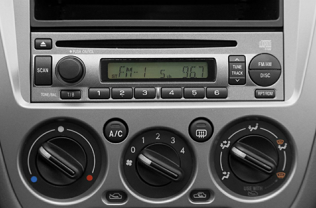 Car radio and manual air conditioning controls with FM tuner and ventilation settings
