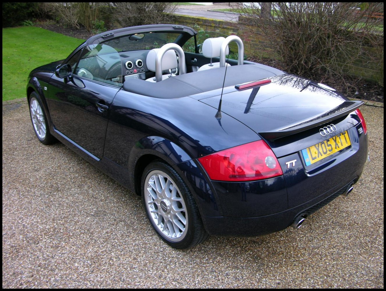 Convertible sports car rear with roll bars and interior dashboard