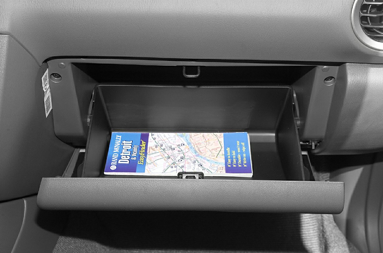 Open glove compartment with map inside in car interior