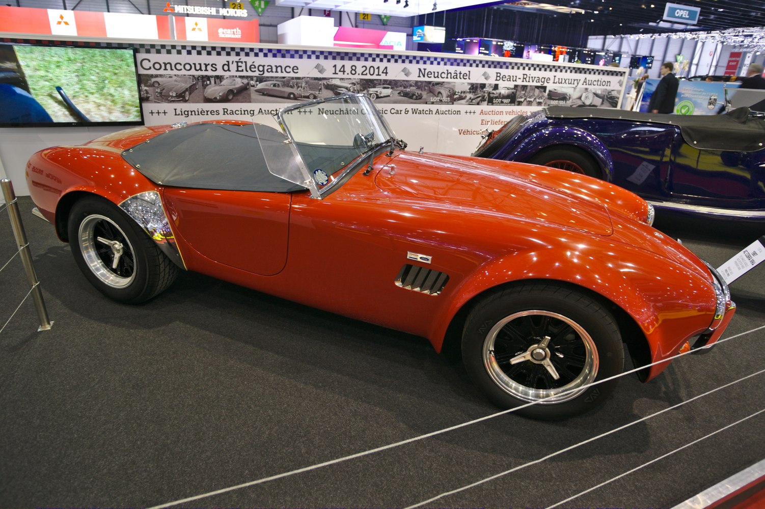 Red vintage roadster with distinctive side vent and polished rims