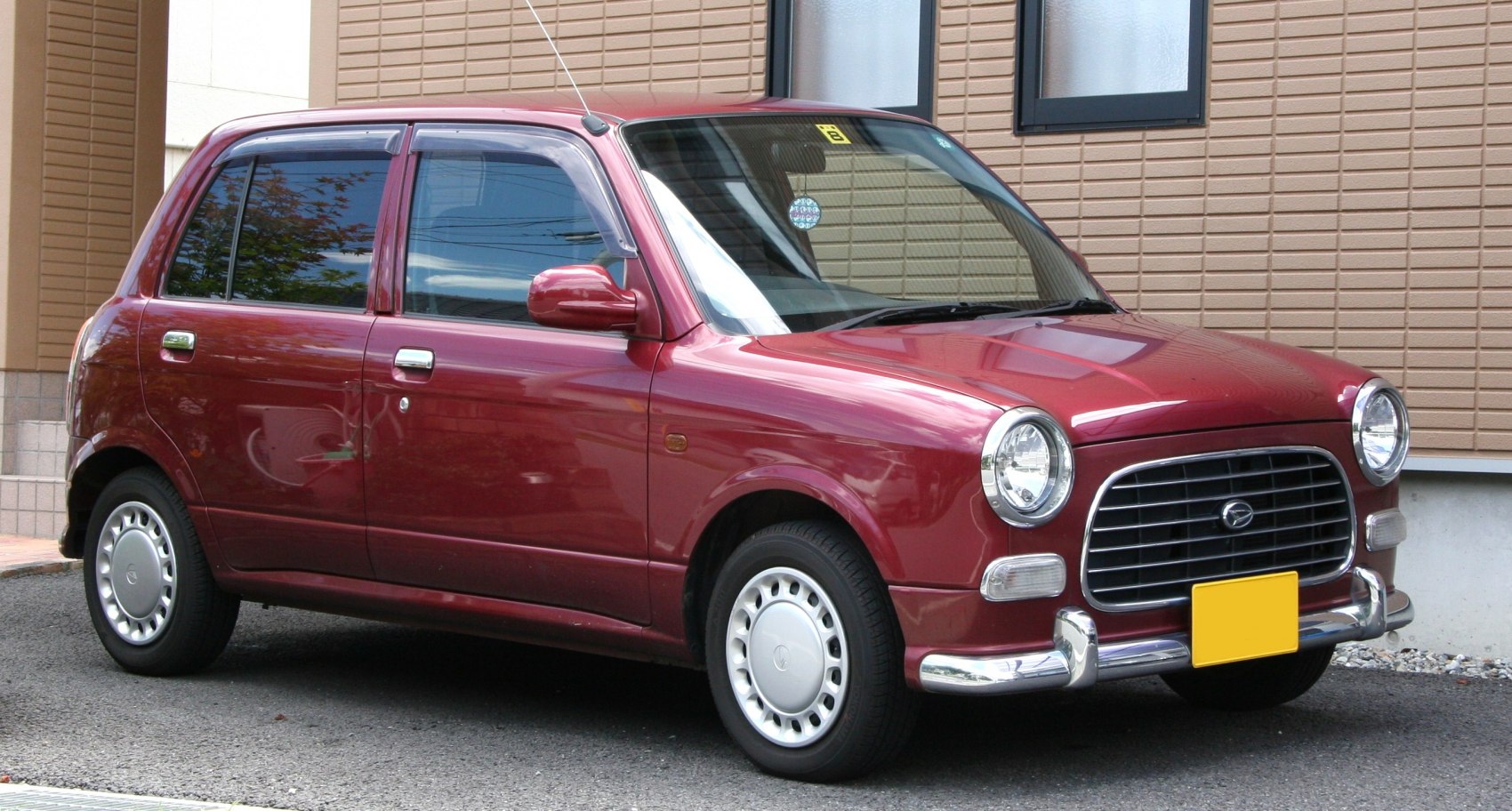 Compact hatchback with round headlights and chrome bumper accents