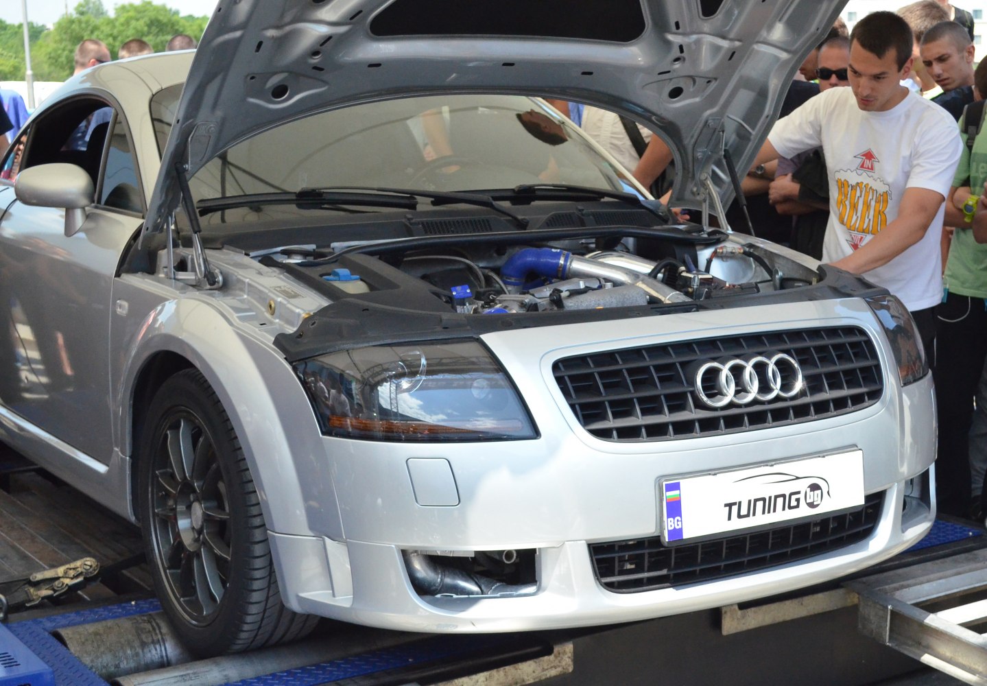 Open hood front view showing engine and sporty wheel design