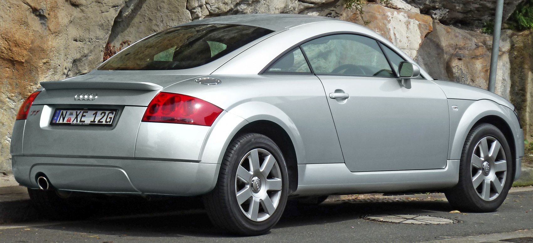 Rear side view of a coupe with spoiler and alloy wheels