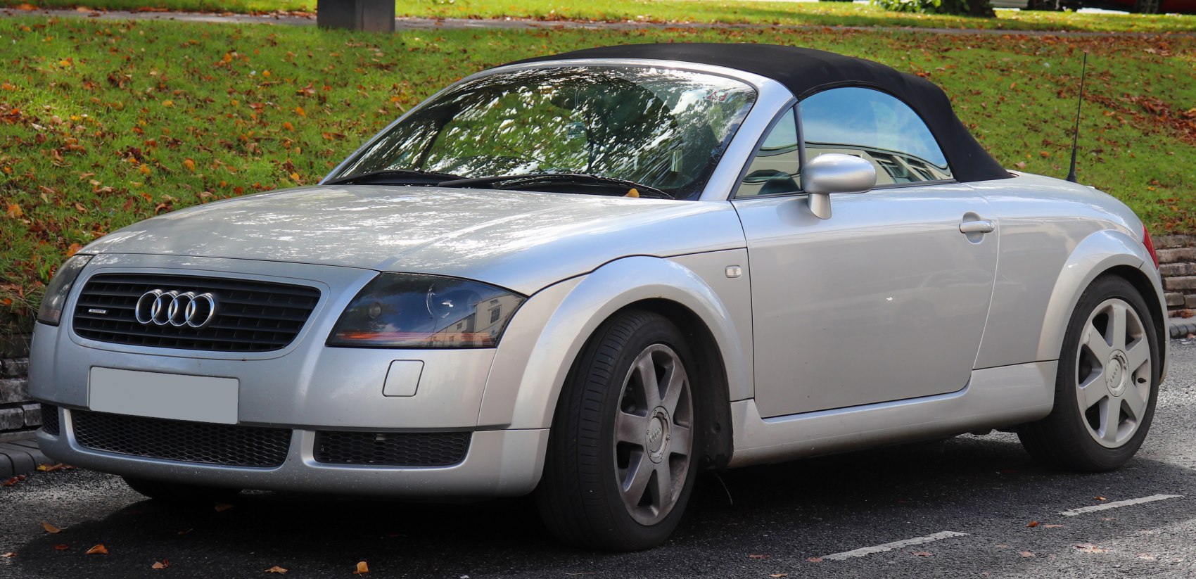 Silver convertible with soft top and alloy wheels, front side view