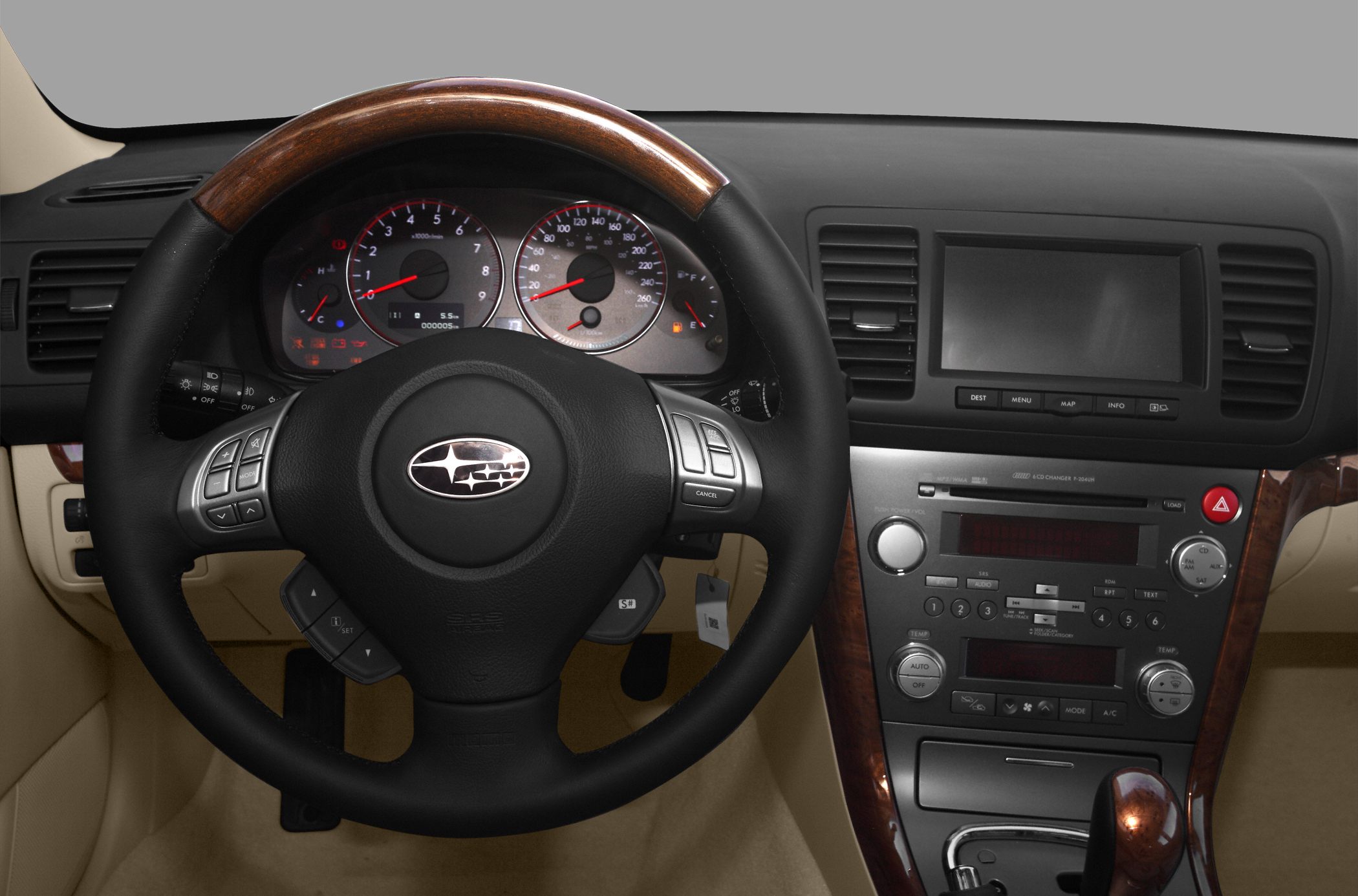 Steering wheel, dashboard gauges, and center console with wood accents