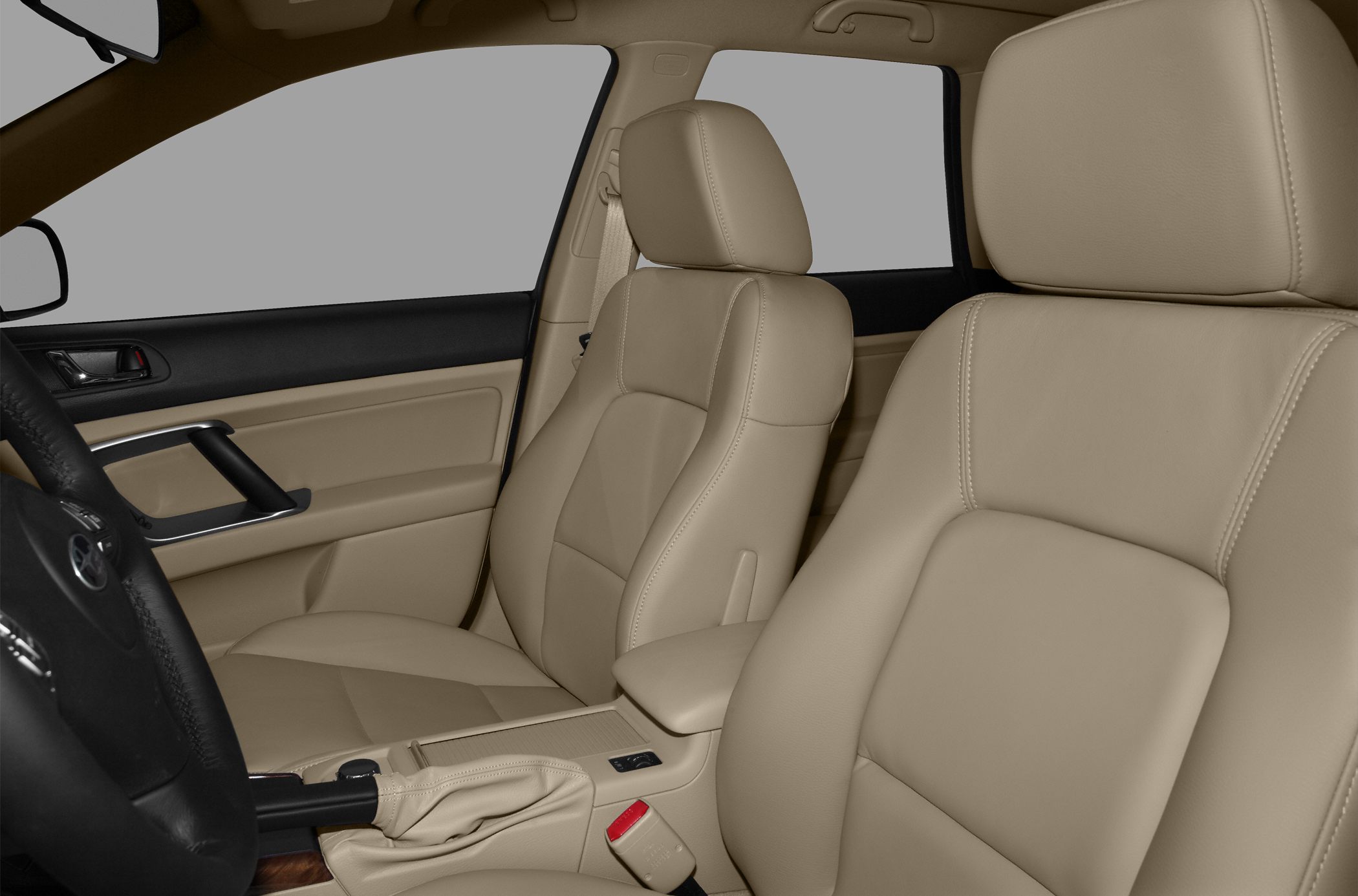 Beige leather front seats with door panel and gear shift.