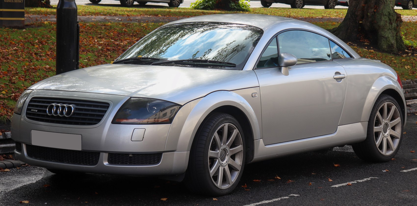 Silver compact coupe with alloy wheels and sleek design.