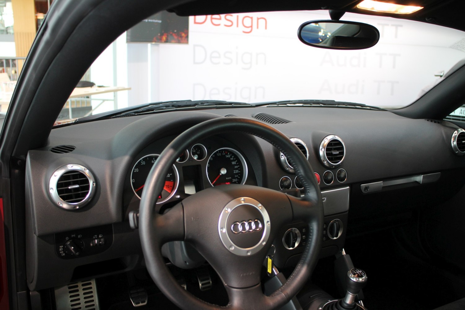 Dashboard with round vents, manual gear shift, and Audi steering wheel