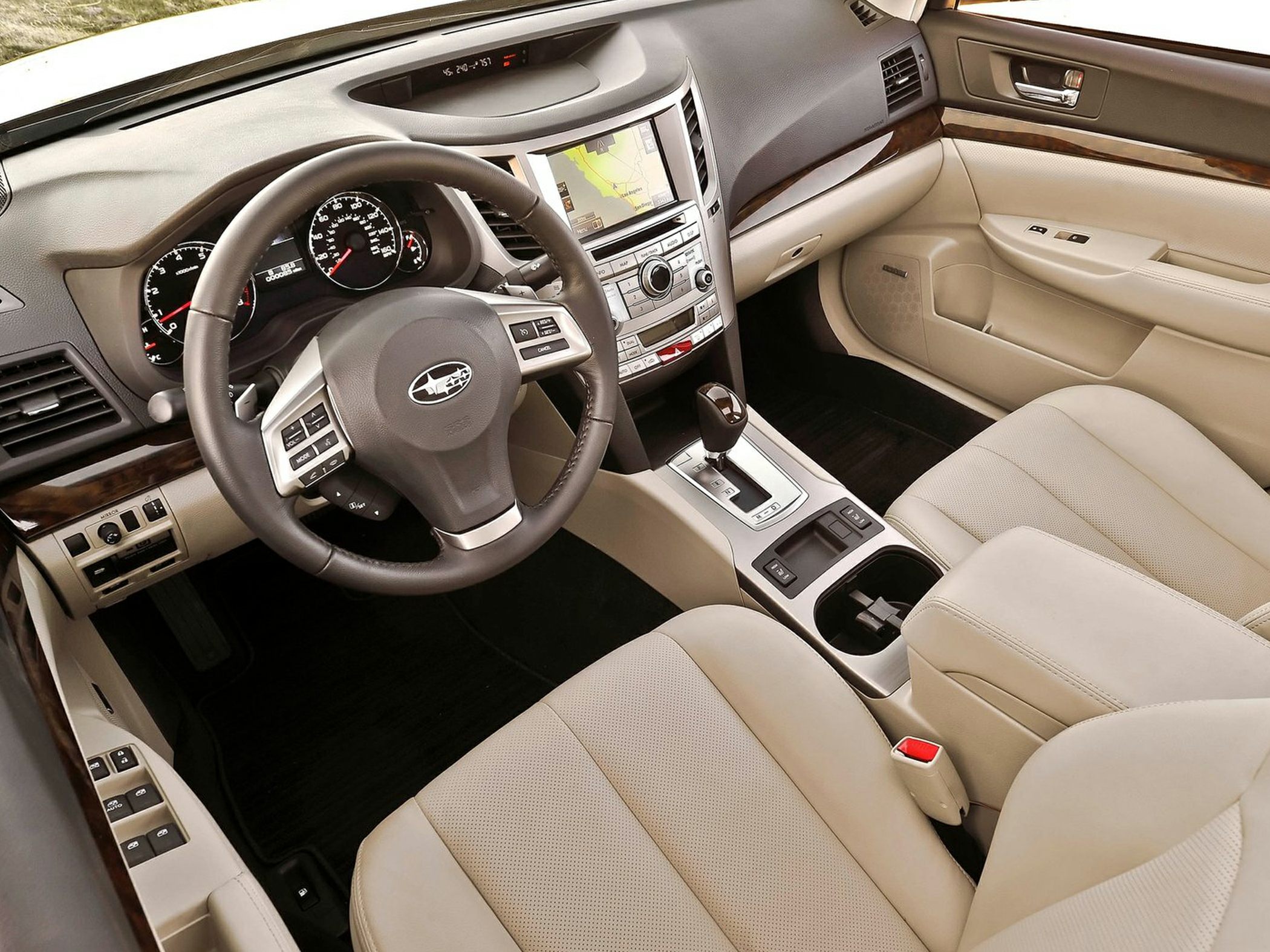 Beige leather interior with steering wheel, touchscreen navigation, and automatic shifter