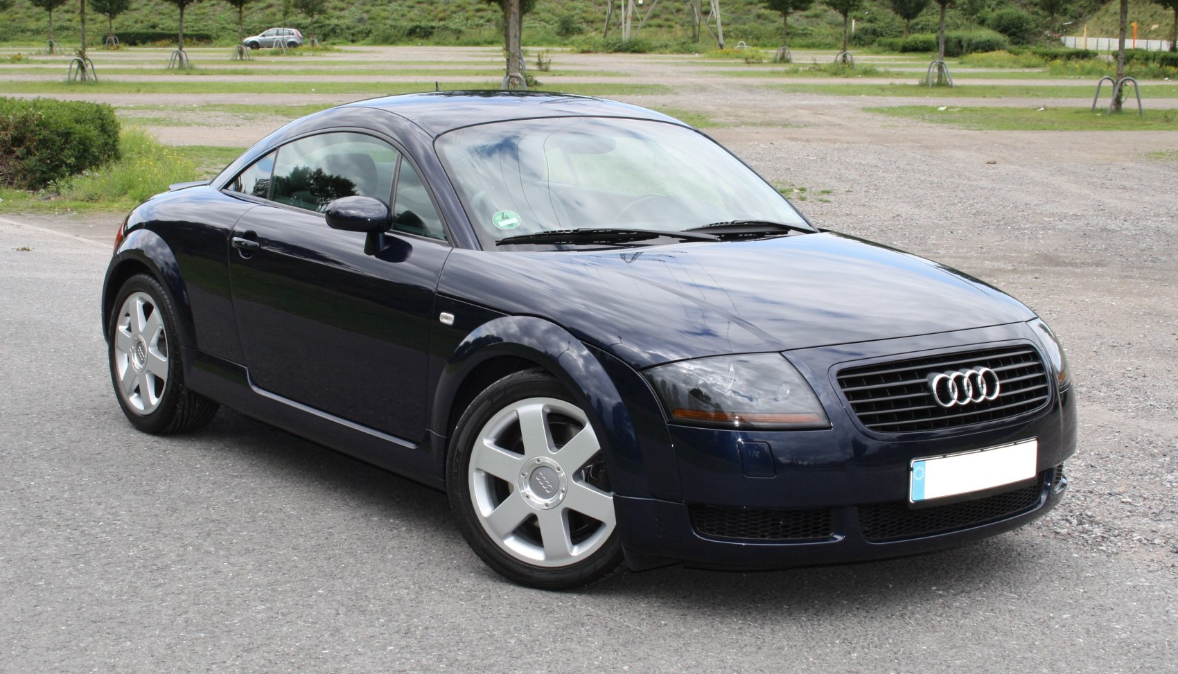 Sleek rounded sports coupe with distinct headlights, front-side view