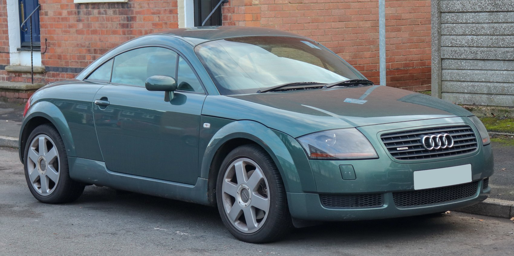 Front-side view of a coupe with curved roofline and alloy wheels