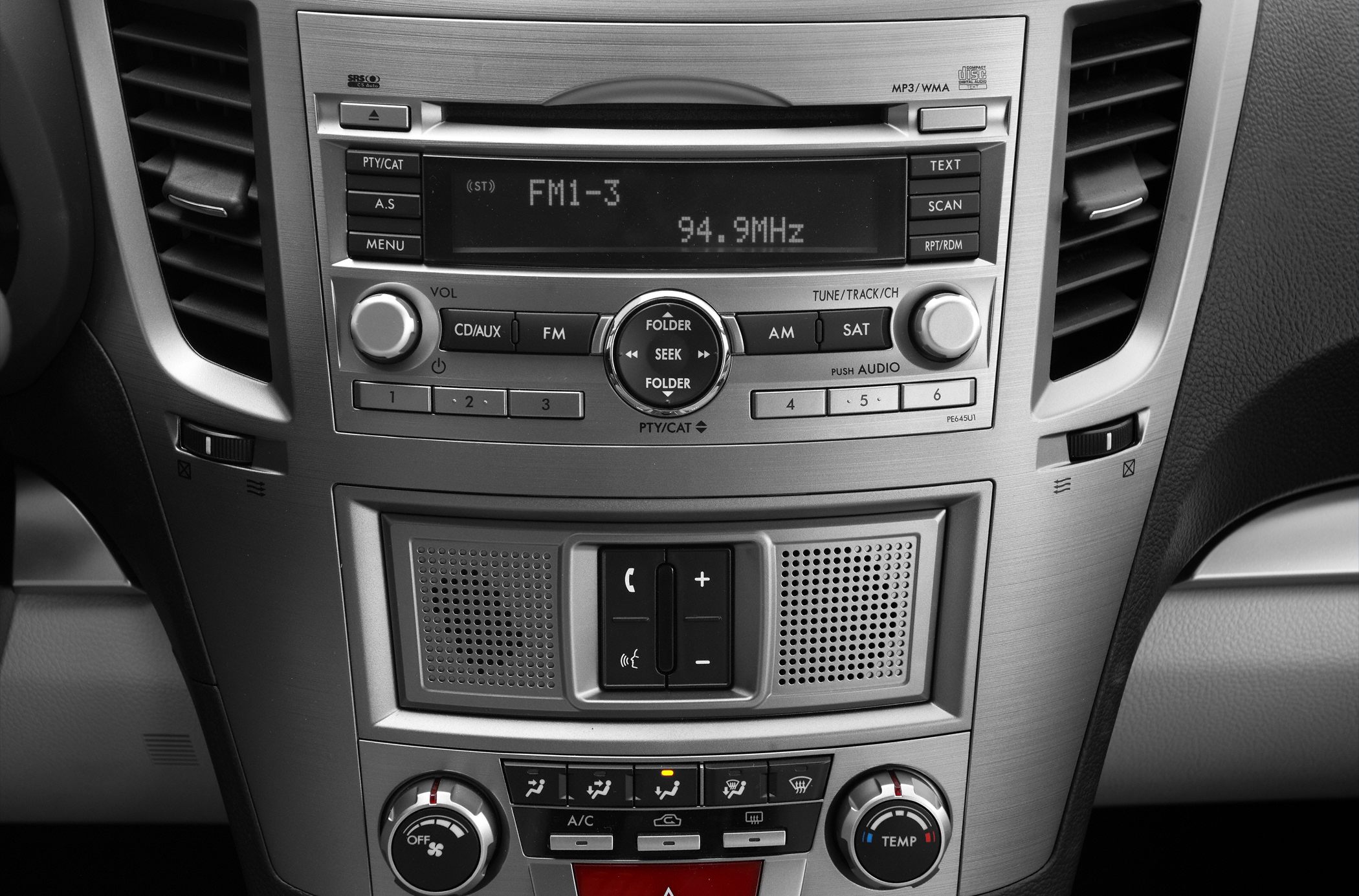 Car center console with audio system, climate controls, and communication buttons