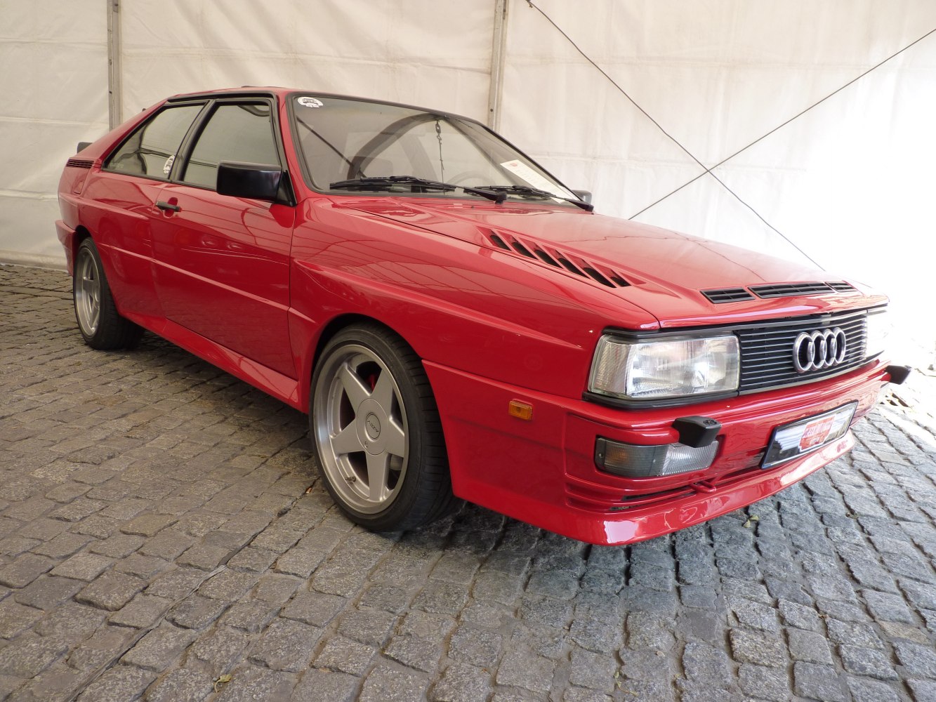 Red coupe with hood vents and 5-spoke alloy wheels