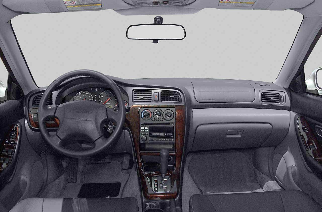 Dashboard and steering wheel with wooden trim and control panel.