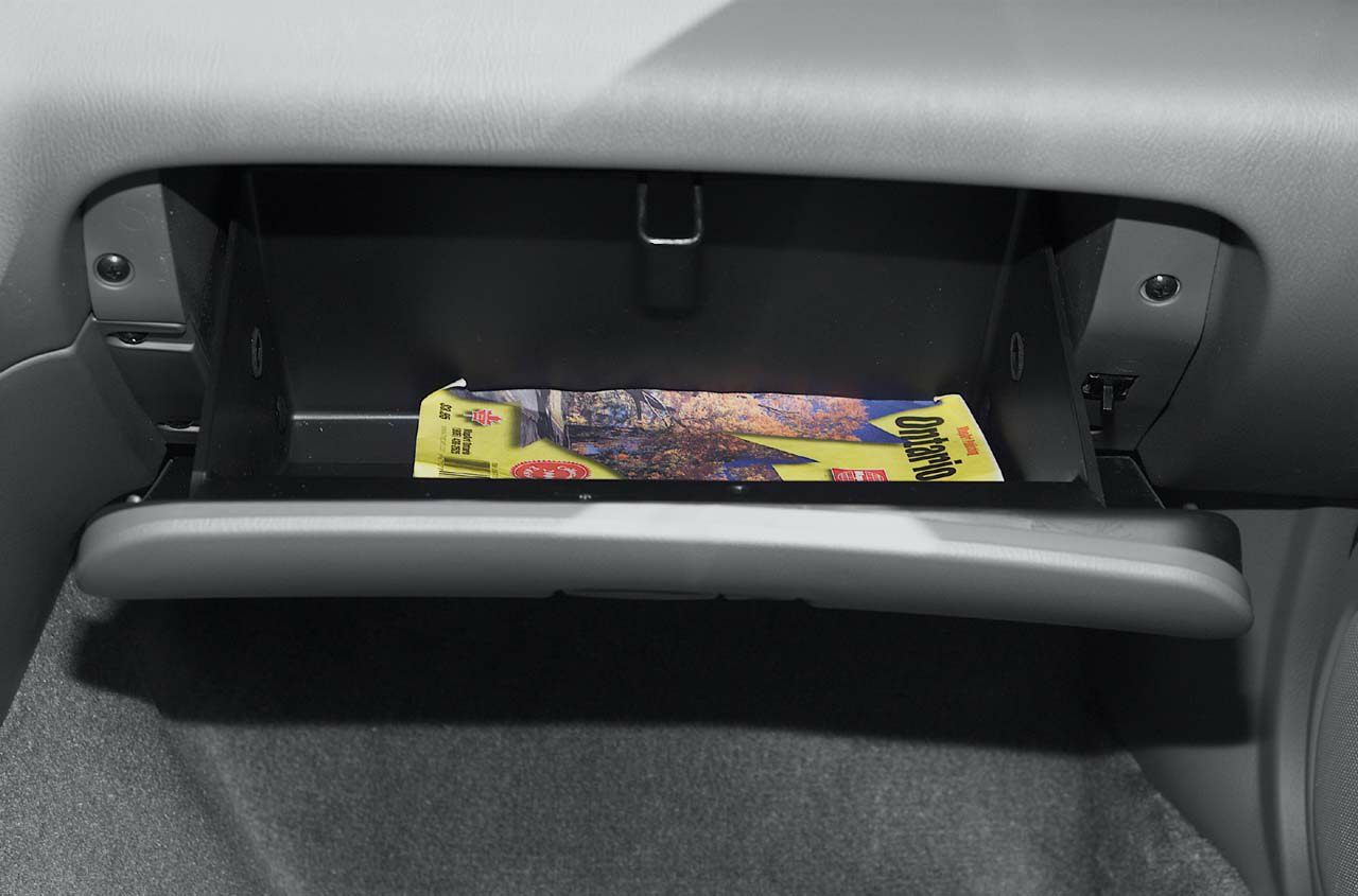 Open glove compartment with guidebook inside car interior
