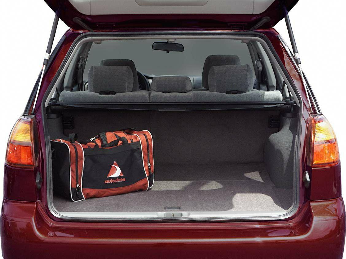 Open rear cargo space of a station wagon with folded rear seats and a travel bag