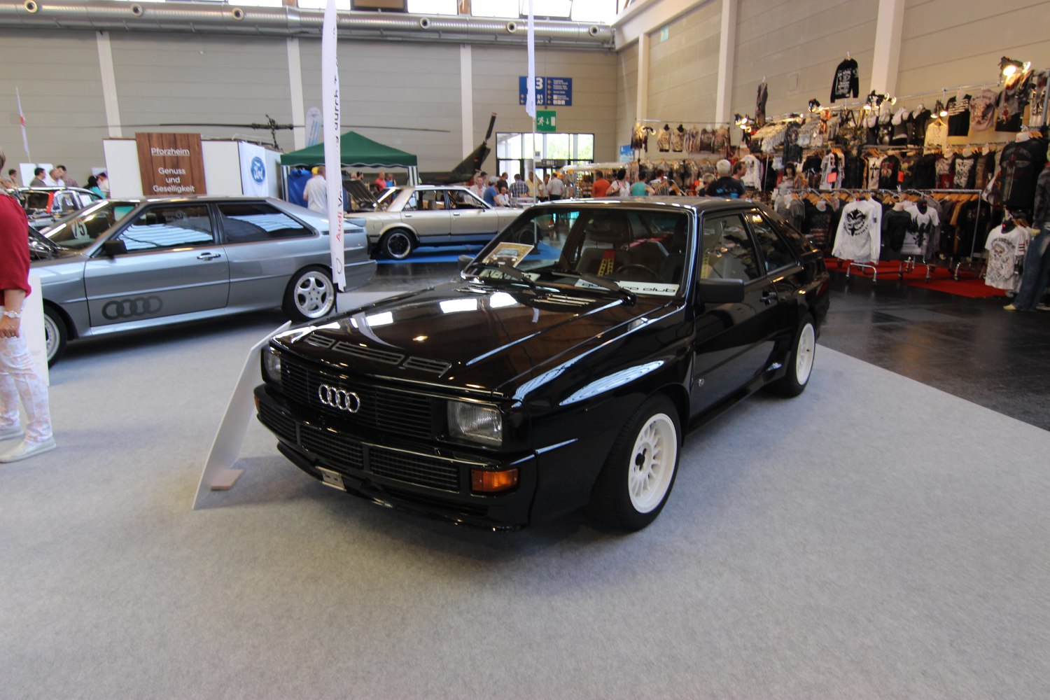 Black classic Audi Quattro with white wheels at car exhibition