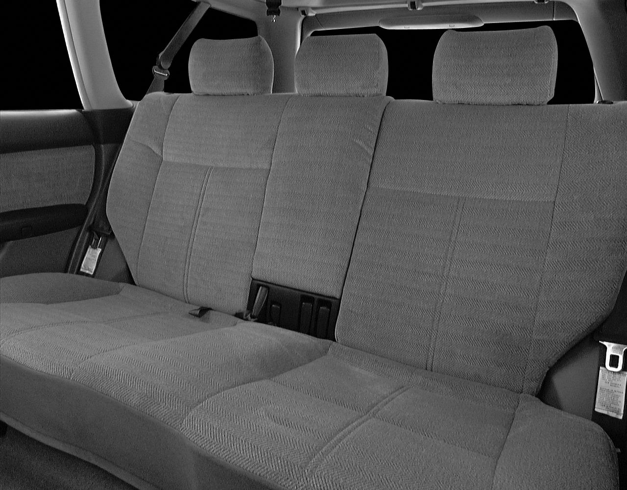 Rear car seat with three fabric headrests and seatbelts