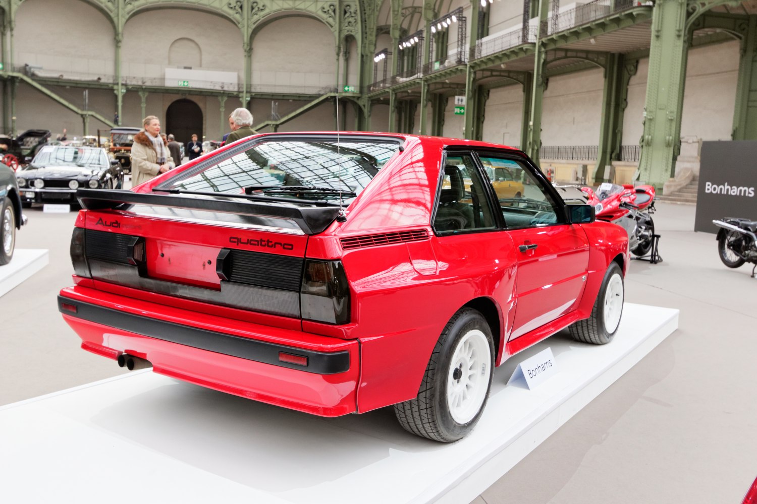 Red hatchback with rear spoiler and white alloy wheels