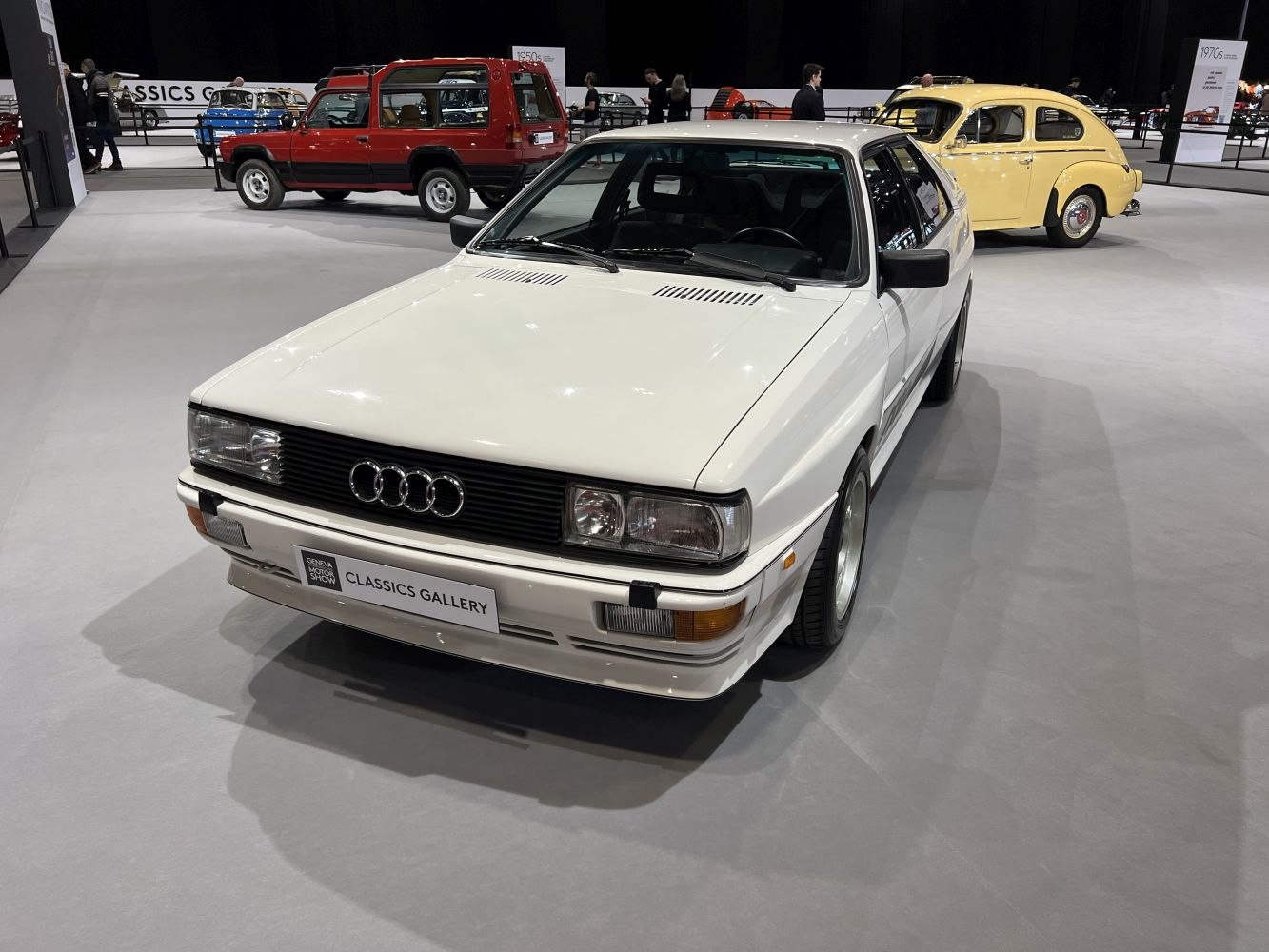 White two-door coupe with quad rectangular headlights and black grille