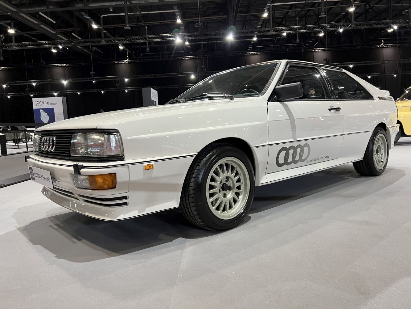 White 1980s sports coupe with multi-spoke wheels and angular design