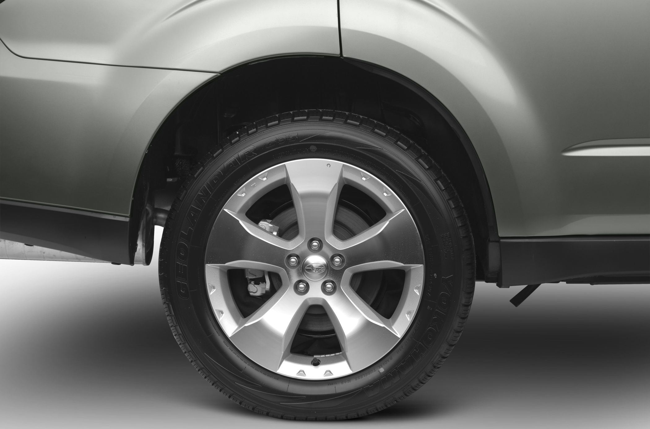 Close-up of alloy wheel and tire with vehicle body panels.