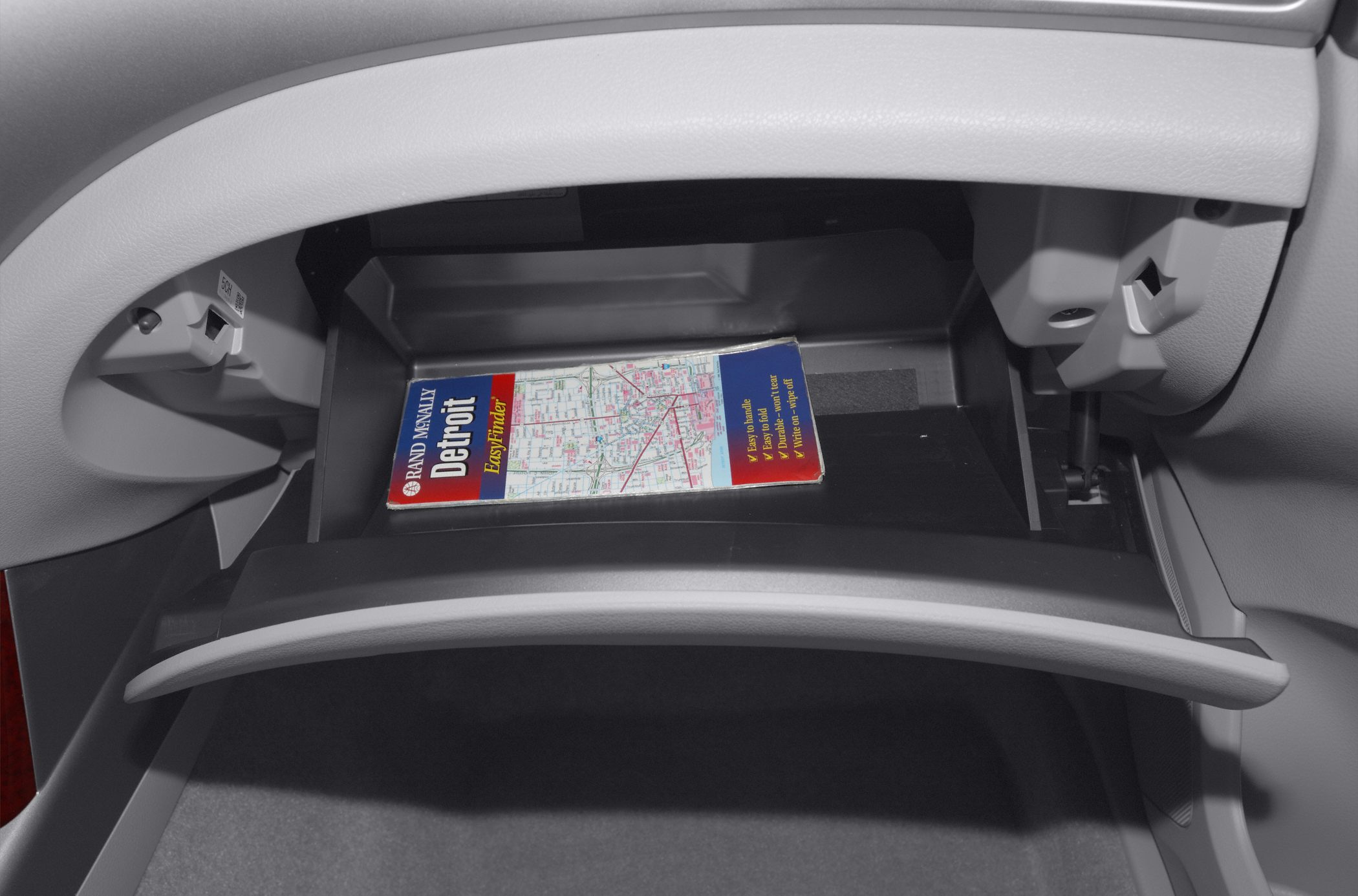 Open glove compartment with map inside car interior