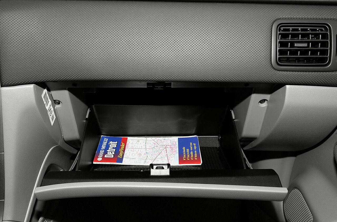 Open glove compartment with map inside and dashboard air vent
