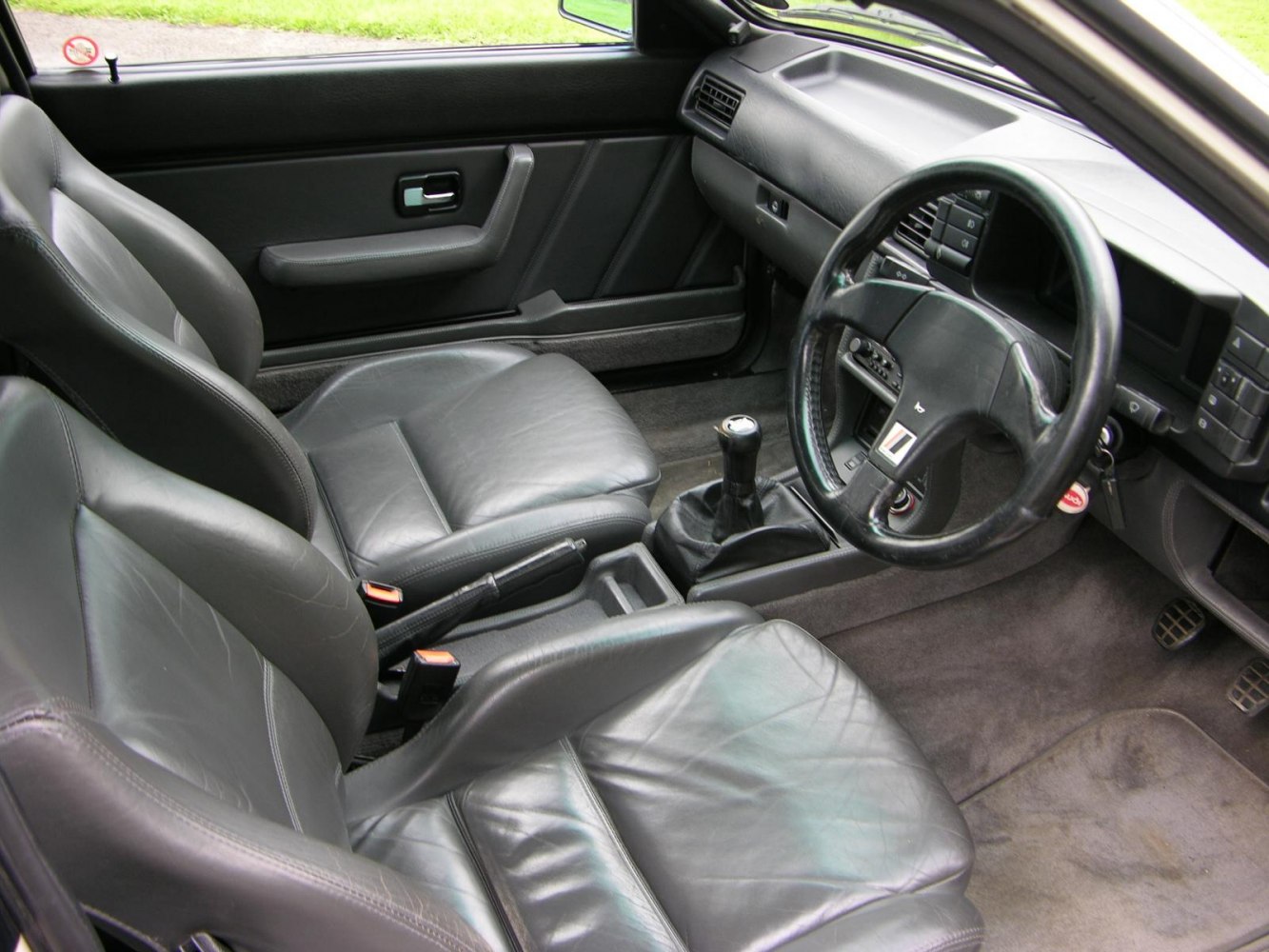 Leather seats and manual gearstick in classic car interior