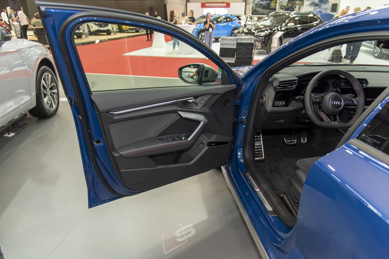 Interior view of driver door panel and sporty steering wheel