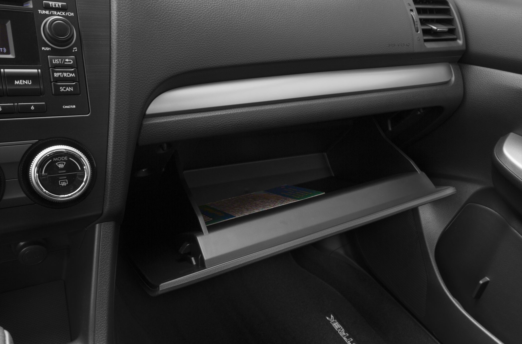 Open glove compartment and dashboard controls in car interior