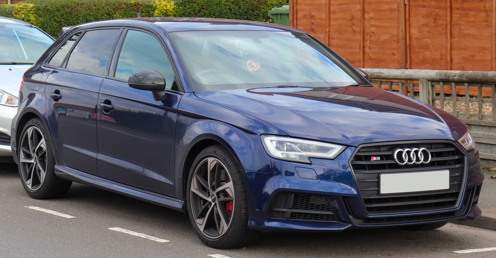Blue hatchback with aggressive front grille and LED headlights.